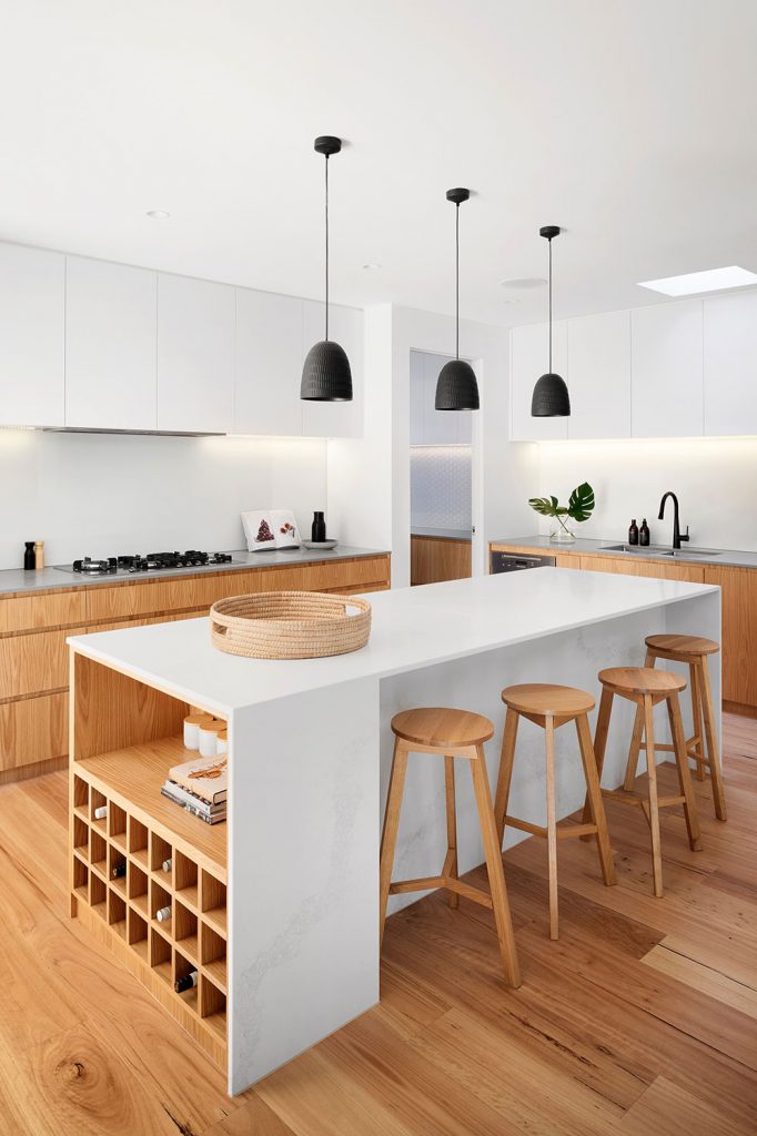 Contemporary Open Kitchen Design with Natural Accents – ideal jewelry and loan Modern kitchen with white cabinets, wood accents, a marble island, pendant lighting, and wooden bar stools – ideal jewelry and loan