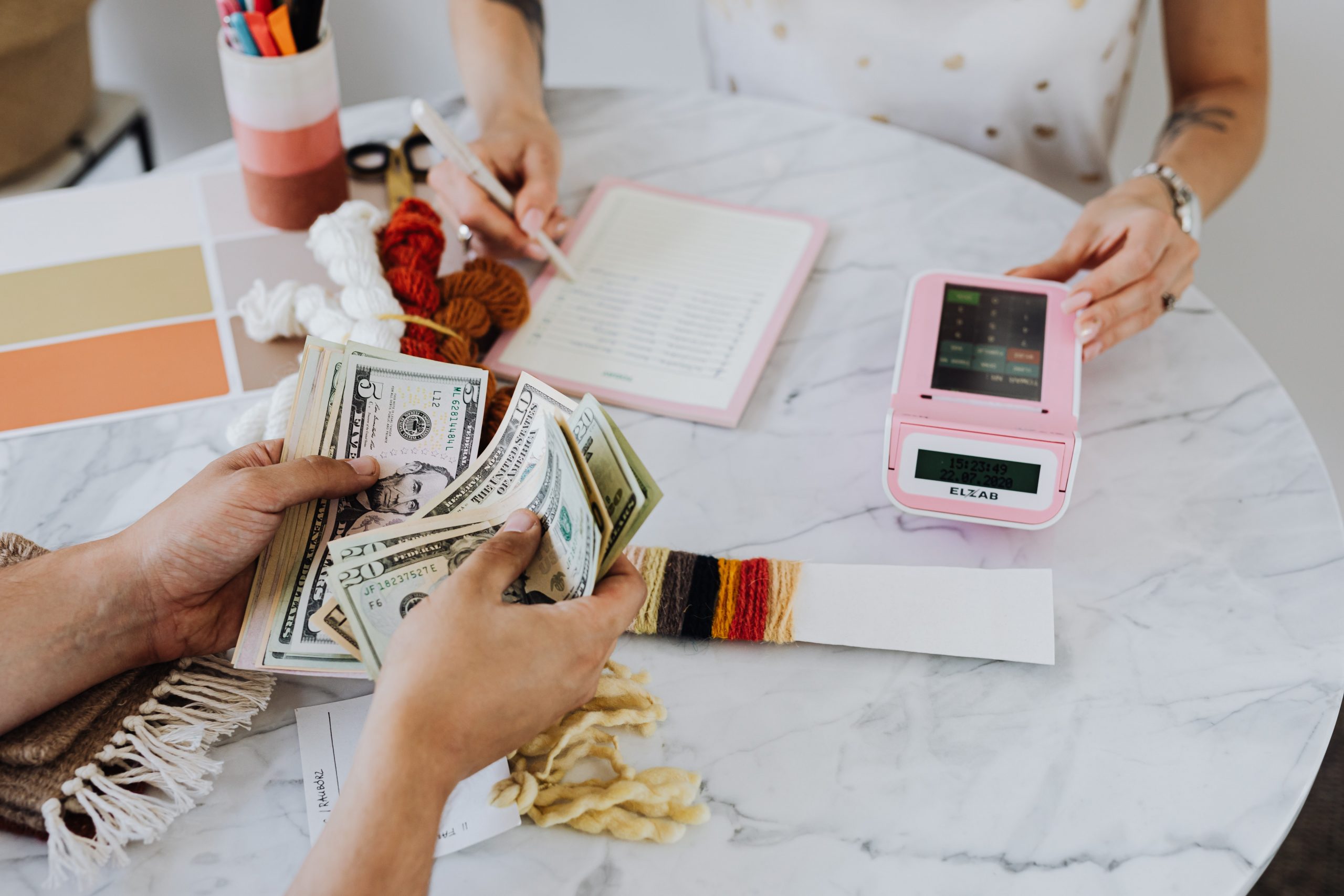 Customer counting cash after selling items at Ideal Jewelry & Loan pawn shop