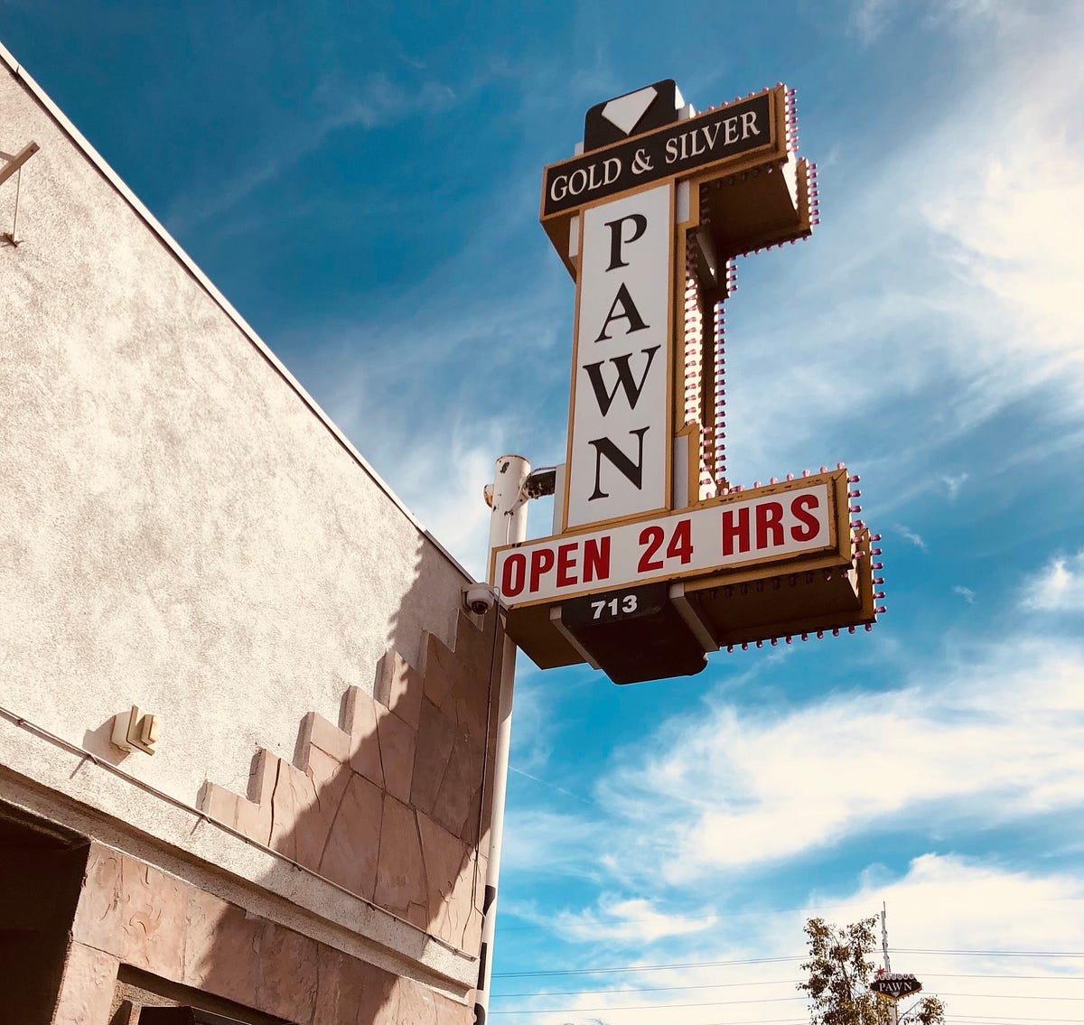Gold & Silver Pawn Shop signboard under blue sky