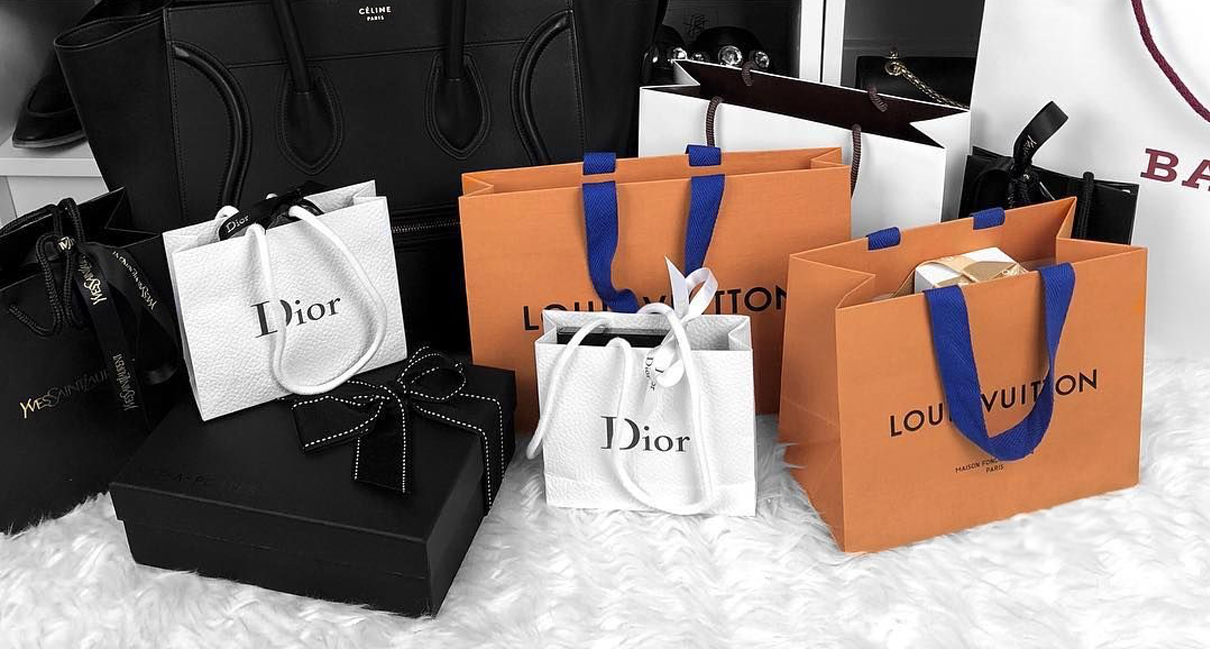 Designer bags and accessories displayed in a well-lit pawn shop case
