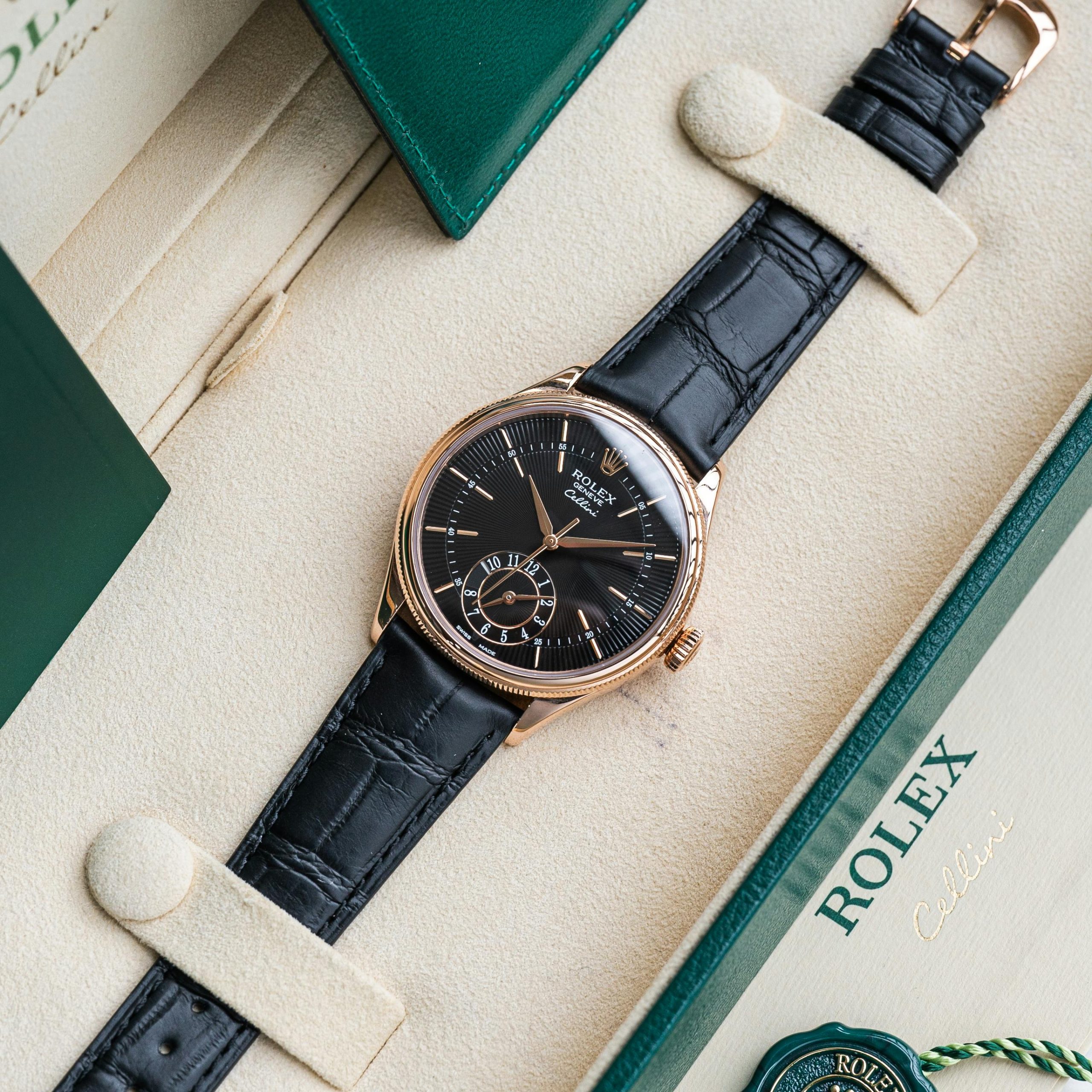 Elegant Rolex Cellini watch with black leather strap in display box.