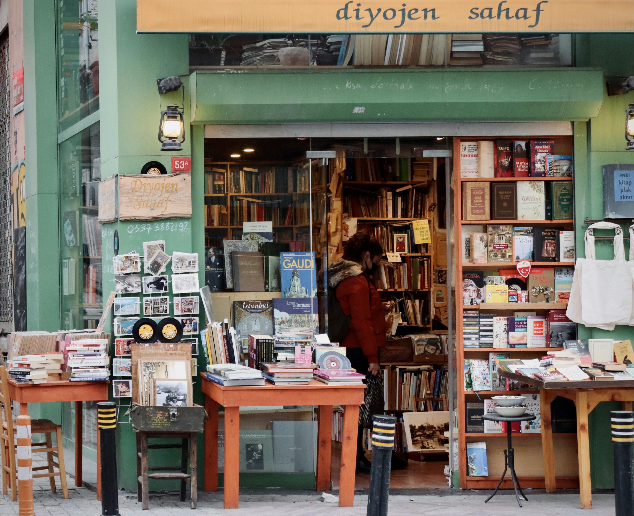 A vintage bookstore storefront with tables of old books and postcards, evoking classic pawn shop charm