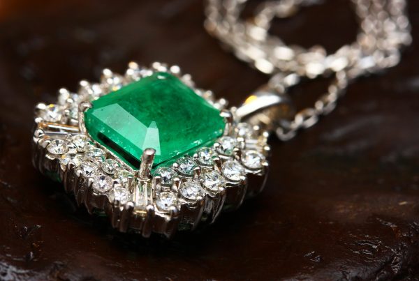 Close-up of a dazzling emerald and diamond pendant on a silver chain