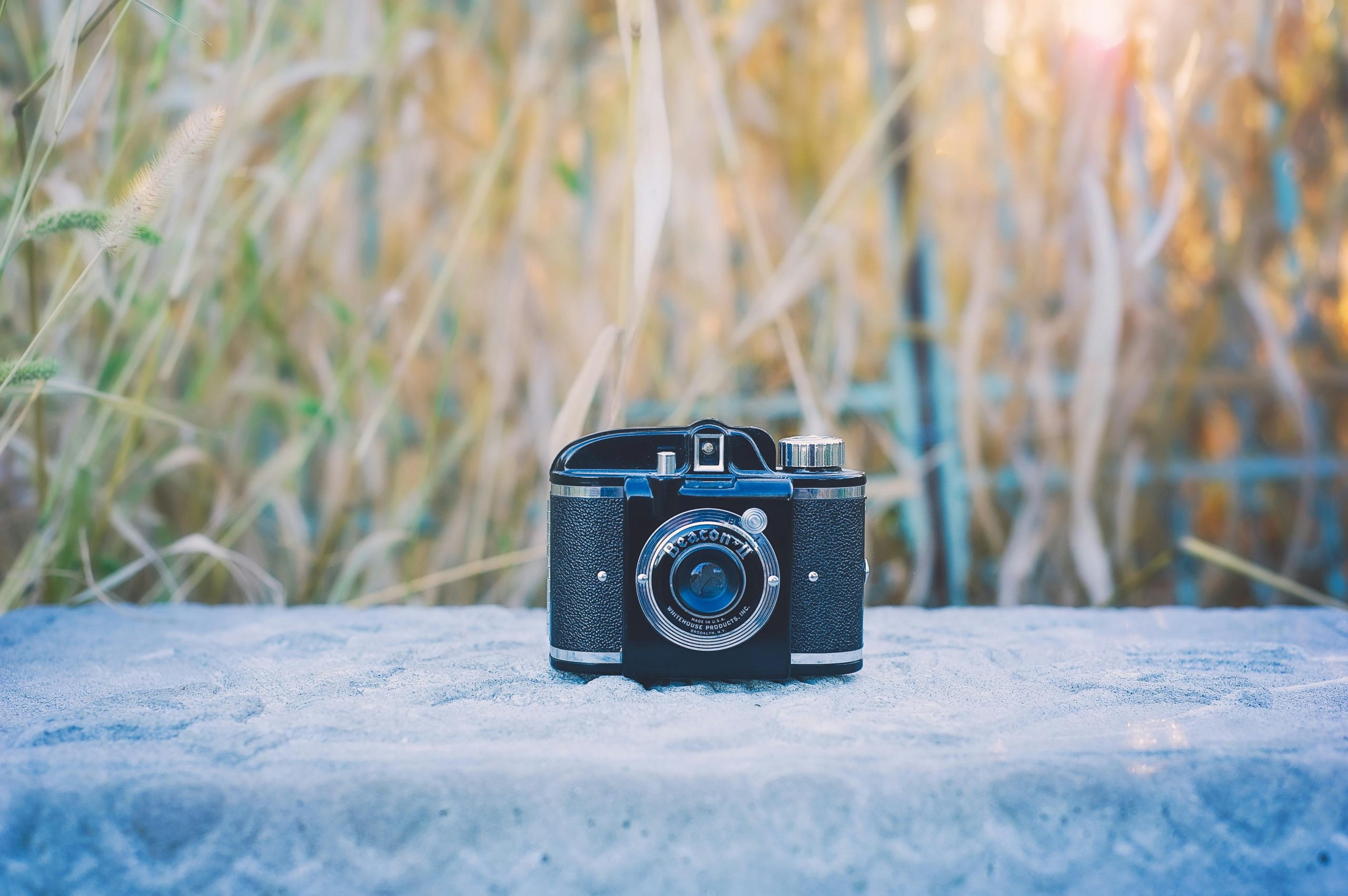 Vintage black camera displayed on concrete surface with a blurred field background, symbolizing valuable pawnable items