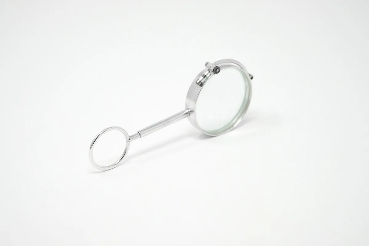 A small silver magnifying glass on a white background